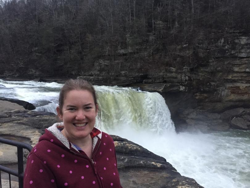 photo of a professor in front of a waterfall