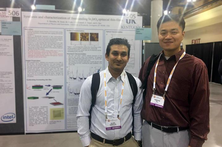 photo of two researchers in front of a chart