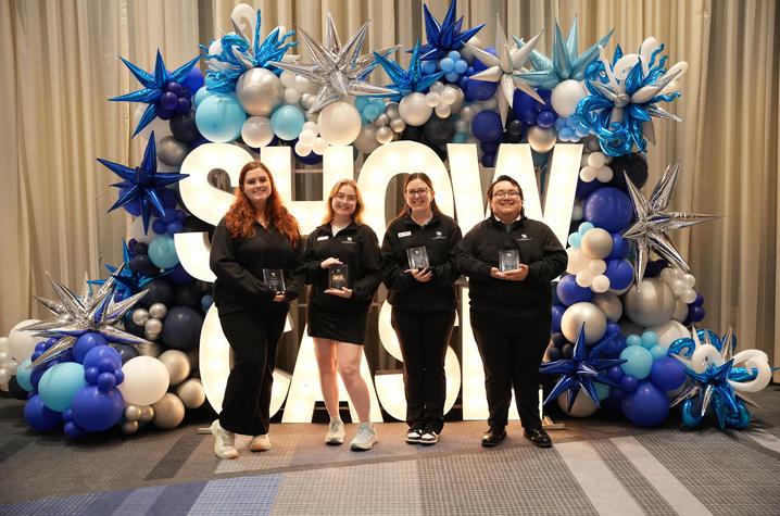 photo of four students with balloons